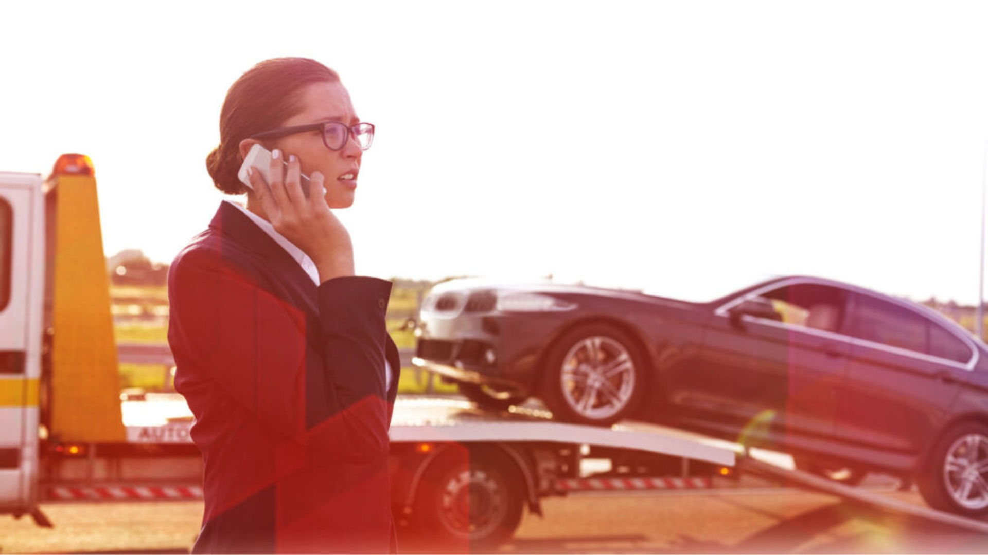 A imagem de uma advogada ao telefone com um carro sendo guinchado ilustra o serviço de defesa em busca e apreensão para Pessoa Jurídica.