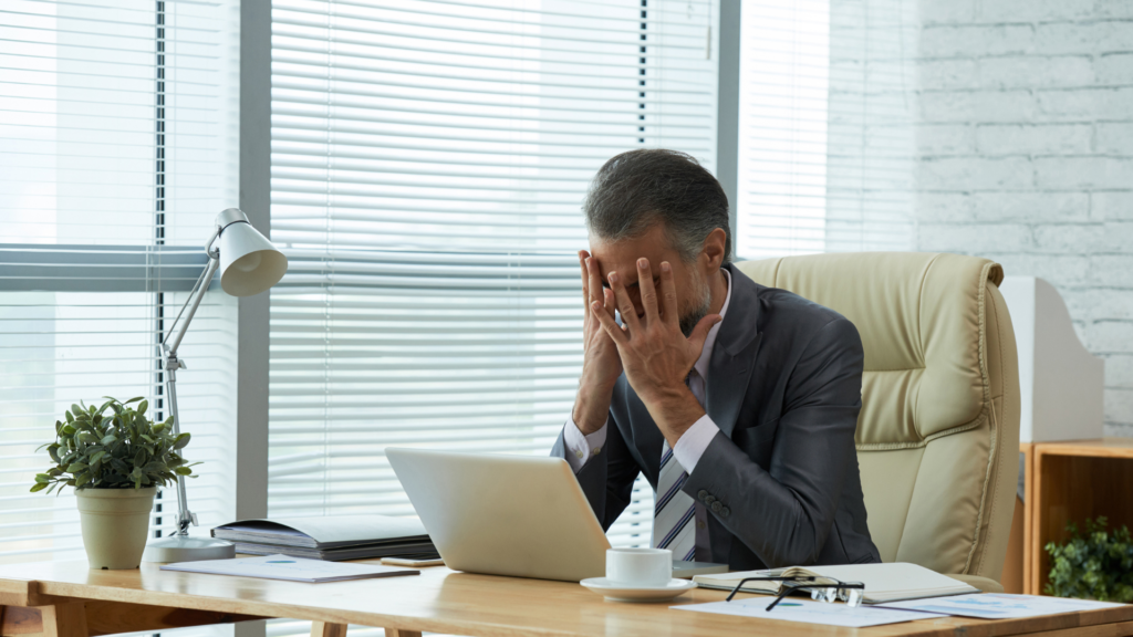 A imagem de um empresário estressado ilustra a necessidade de assessoria jurídica em direito bancário e recuperação financeira para Pessoa Jurídica.